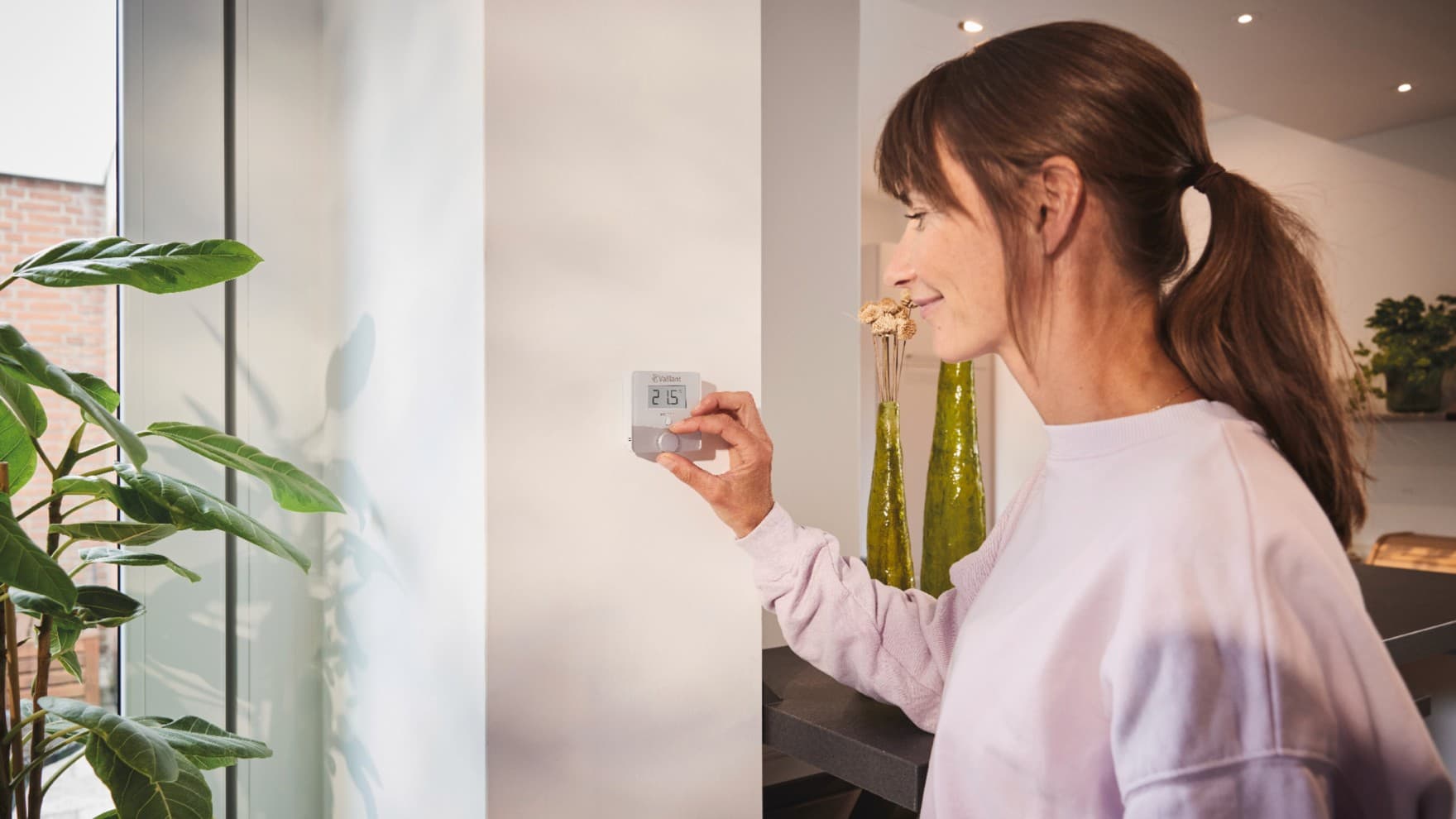 Kvinde, der bruger Vaillant rumtermostat sensoROOM
