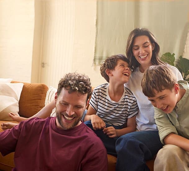 En familie, der sidder på en sofa i stuen