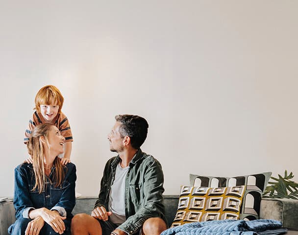 Familien sidder på sofaen i stuen