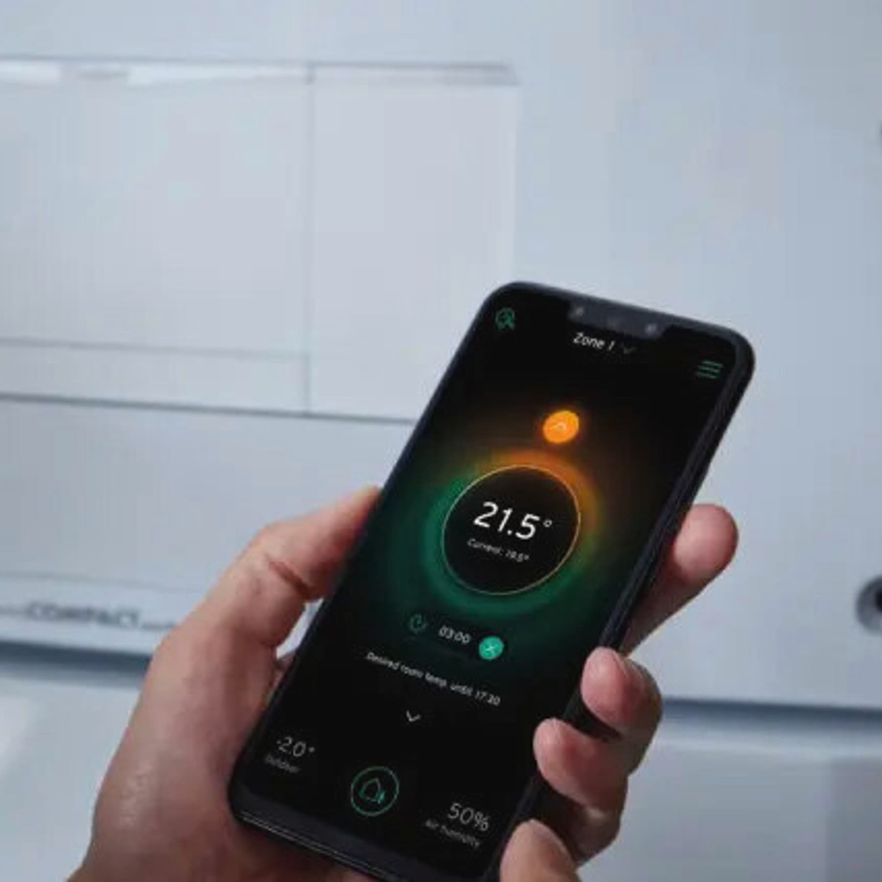 Hånd holder en mobil som viser temperatur