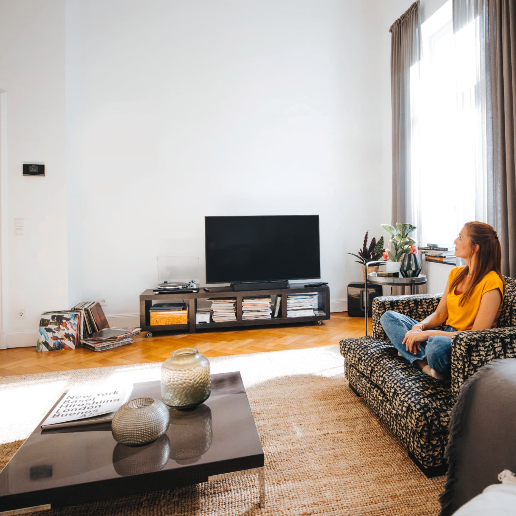 En kvinde, der sidder i sin sofa og nyder freden og roen ved den perfekte temperatur