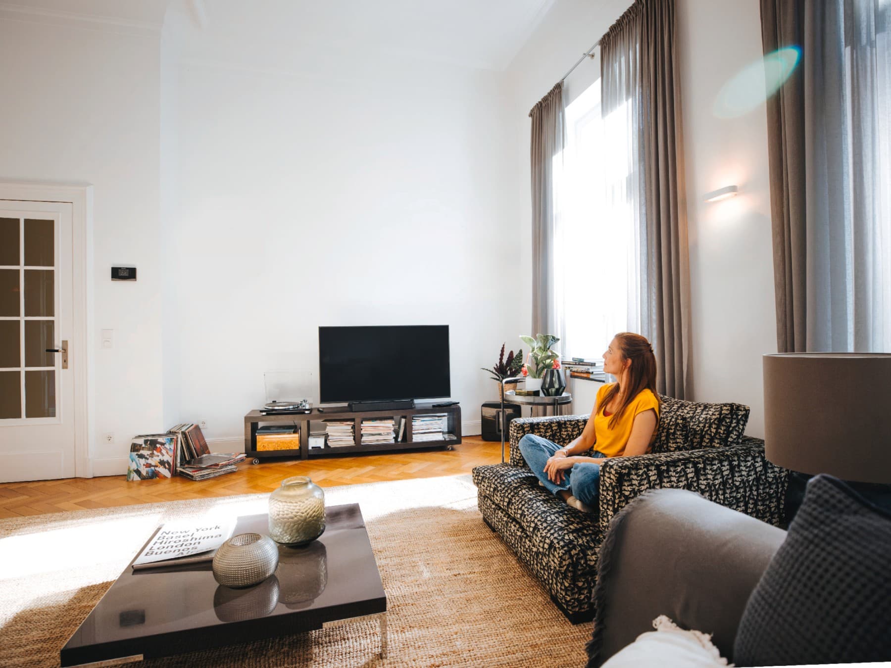 Kvinde sidder på sin sofa og nyder freden og roen ved den perfekte temperatur