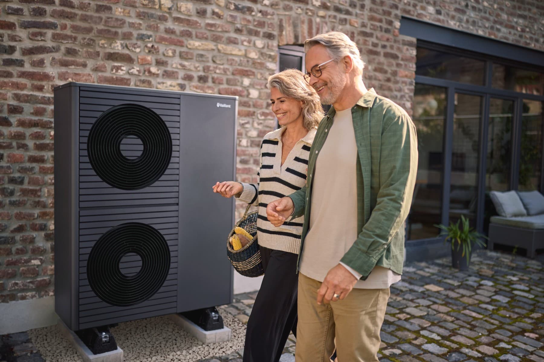 Midaldrende par foran en Vaillant-varmepumpe
