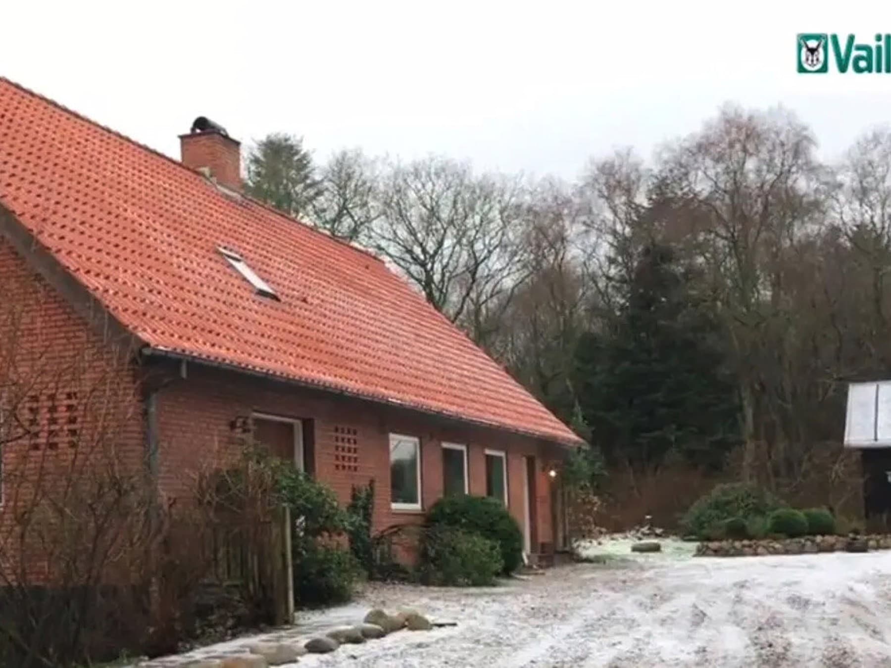 Et rødt murstenshus med rødt tegltag
