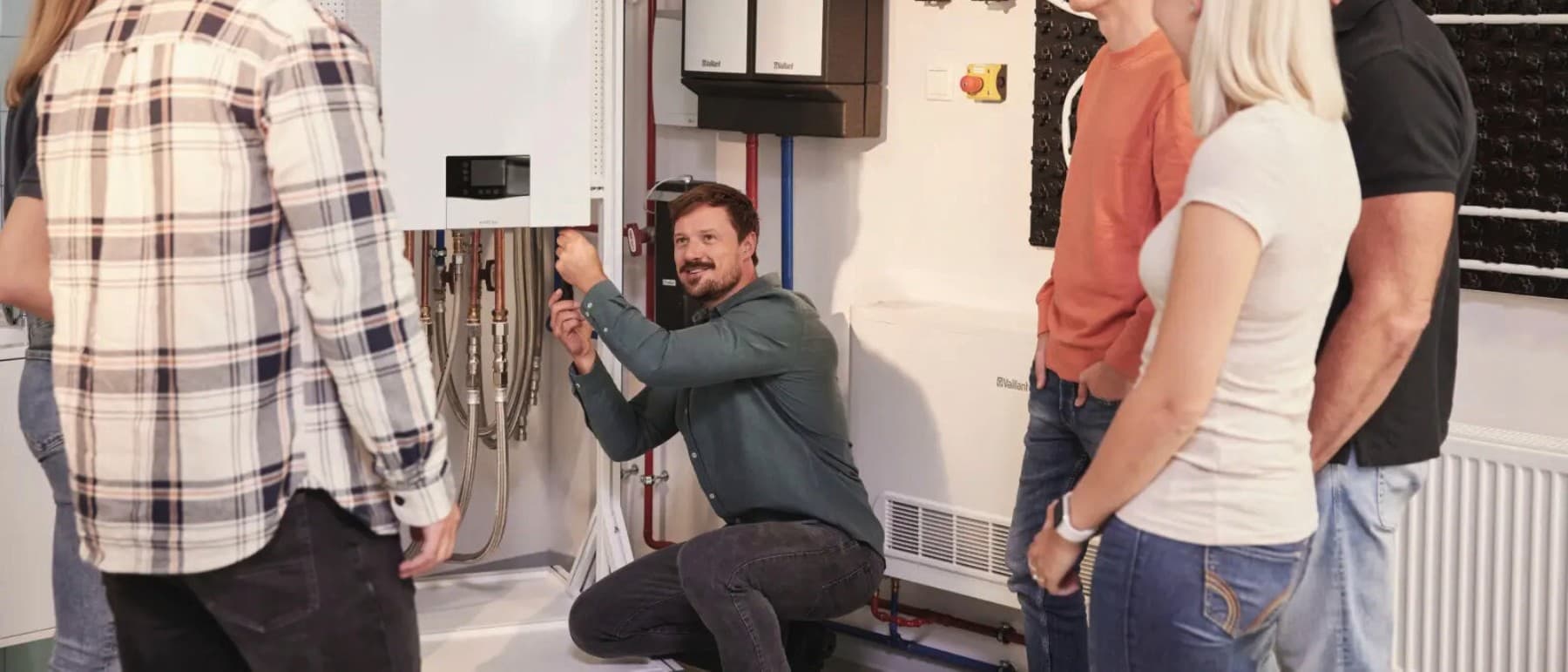 Vaillant installatør forklarer en varmepumpe til en gruppe mennesker